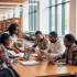 A group of African Americans sitting around a table using laptops